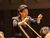 Eine Frau dirigiert ein Orchester