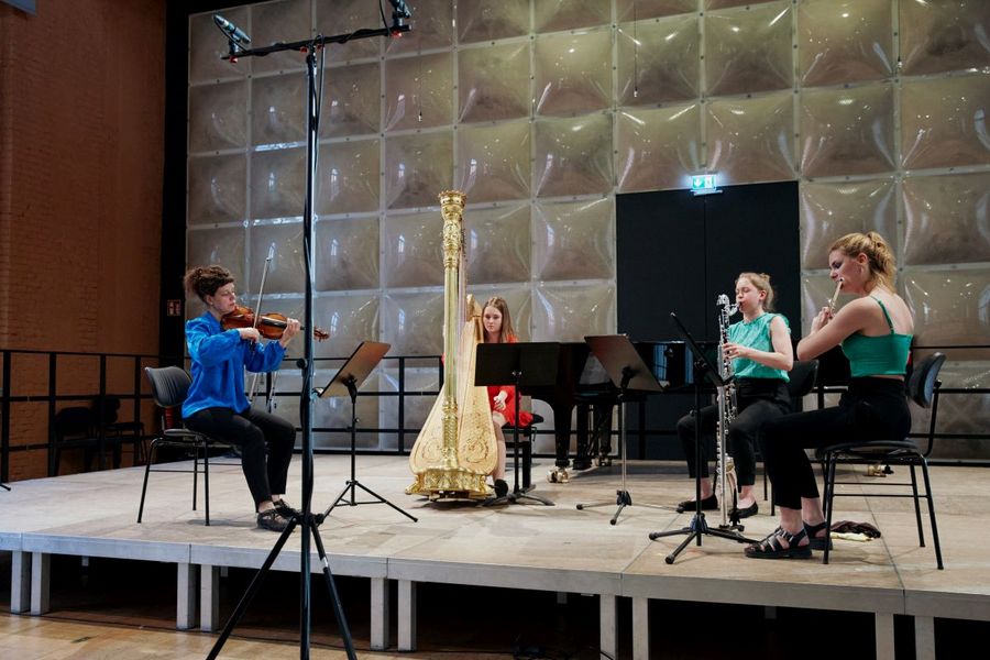 Geigerin, Harfenistin, Bassklarinettistin und Querflötistin spielen auf der Bühne des Krönungskutschen-Saal