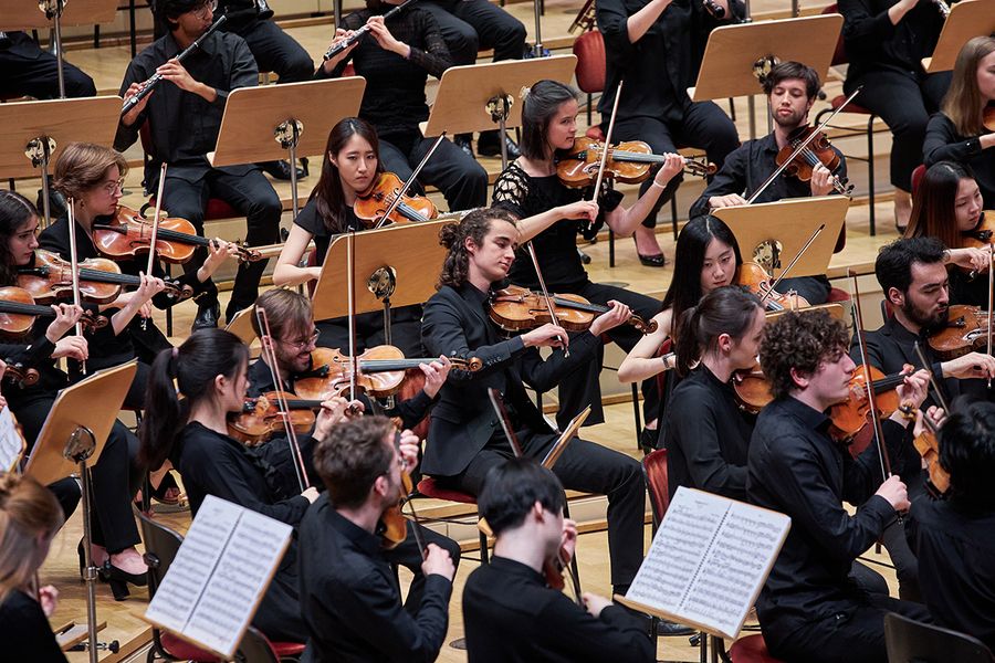 Studierende spielen auf Streichinstrumenten als Teil des Orchesters