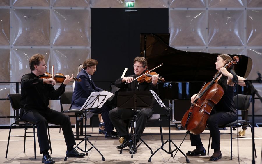 Drei Streicher und ein Pianist auf einer Bühne während eines Konzerts