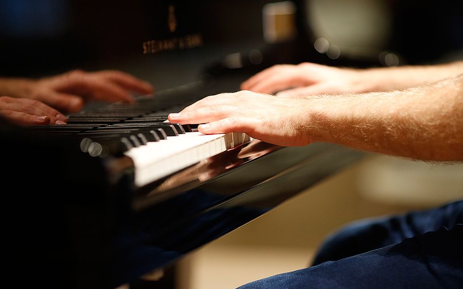 Hände auf einer Klaviertastatur 