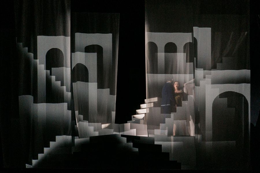 Zwei Gesangstudierende inmitten eines schwarz-weiß ausgeleuchteten Bühnenbilds