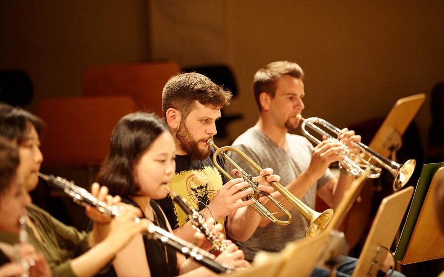 Zwei Oboistinnen und zwei Trompeter während einer Probe