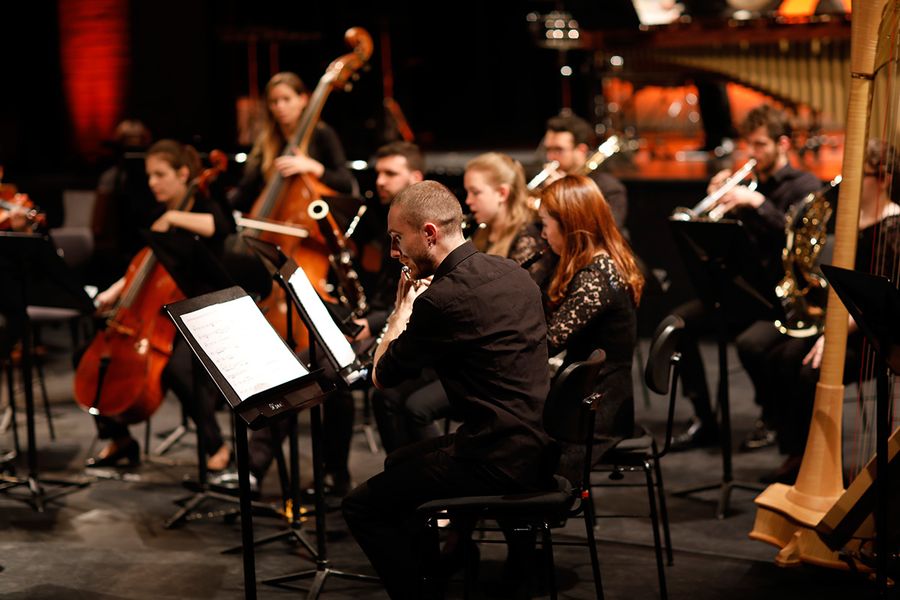 Studierende mit Instrumenten auf einer Bühne während eines Konzertes