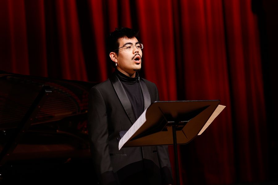 Gesangstudent auf der Bühne des Studiosaals vor rotem Vorhang