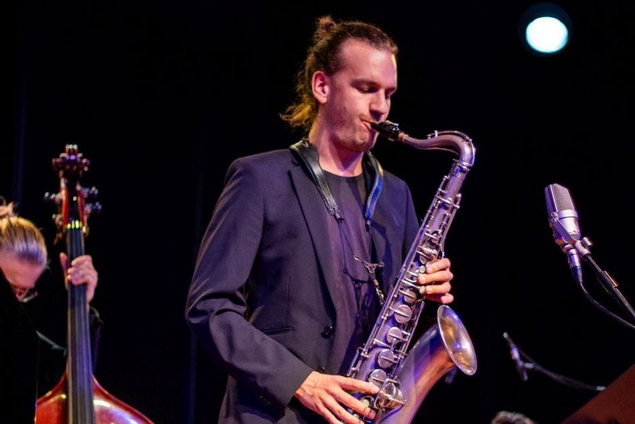 Saxophonist musiziert im Jazzensemble auf der der Bühne