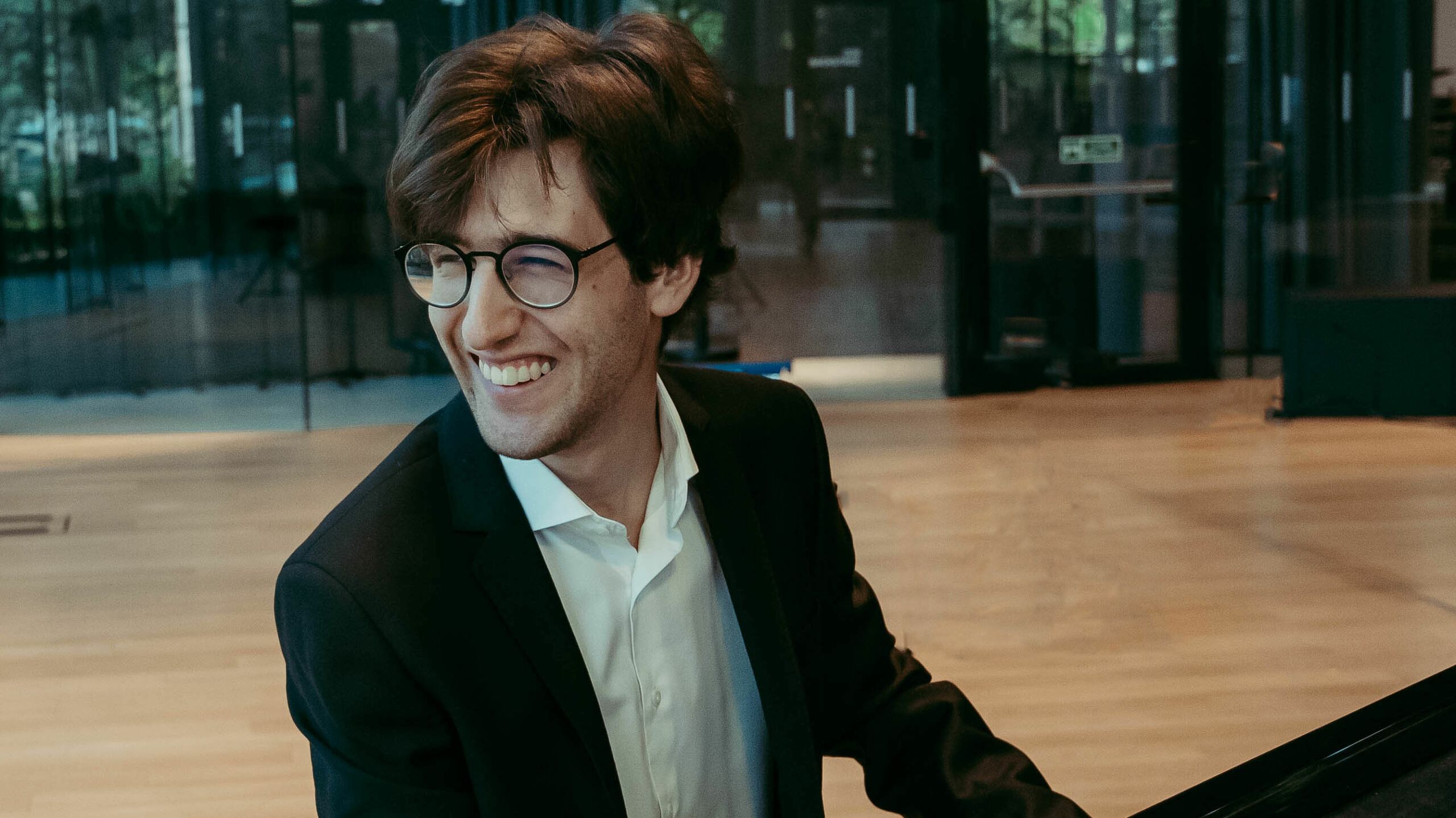 Junger Pianist mit Brille am Flügel