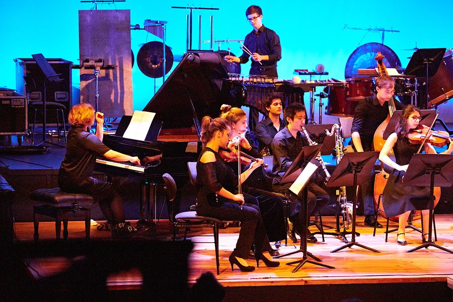 Ensemble aus Studierenden mit Instrumenten auf einer Bühne während eines Konzertes
