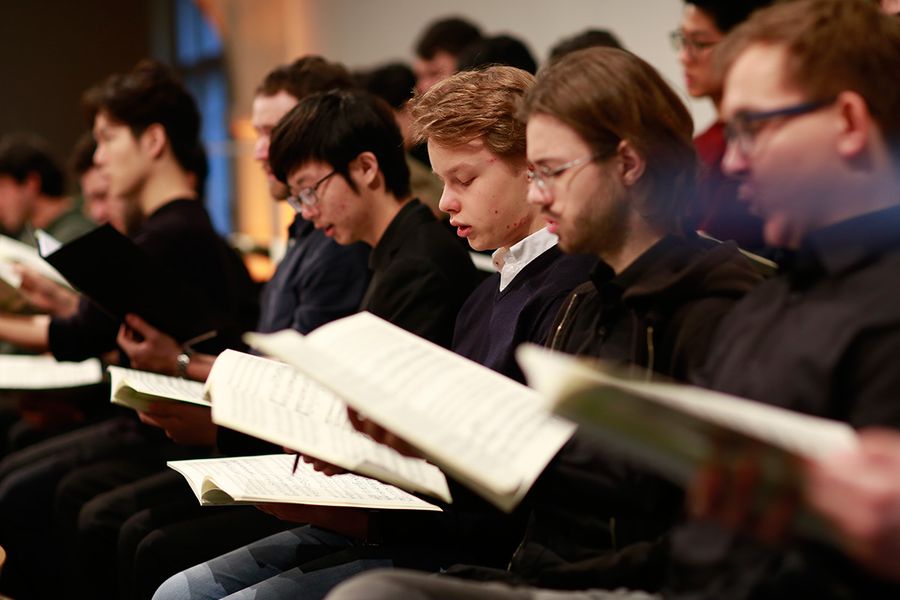 Singende Studenten mit Noten in den Händen