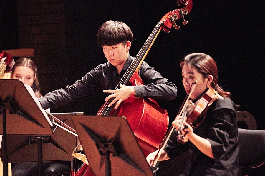 Student mit Kontrabass und Studentin mit Bratsche während eines Konzertes