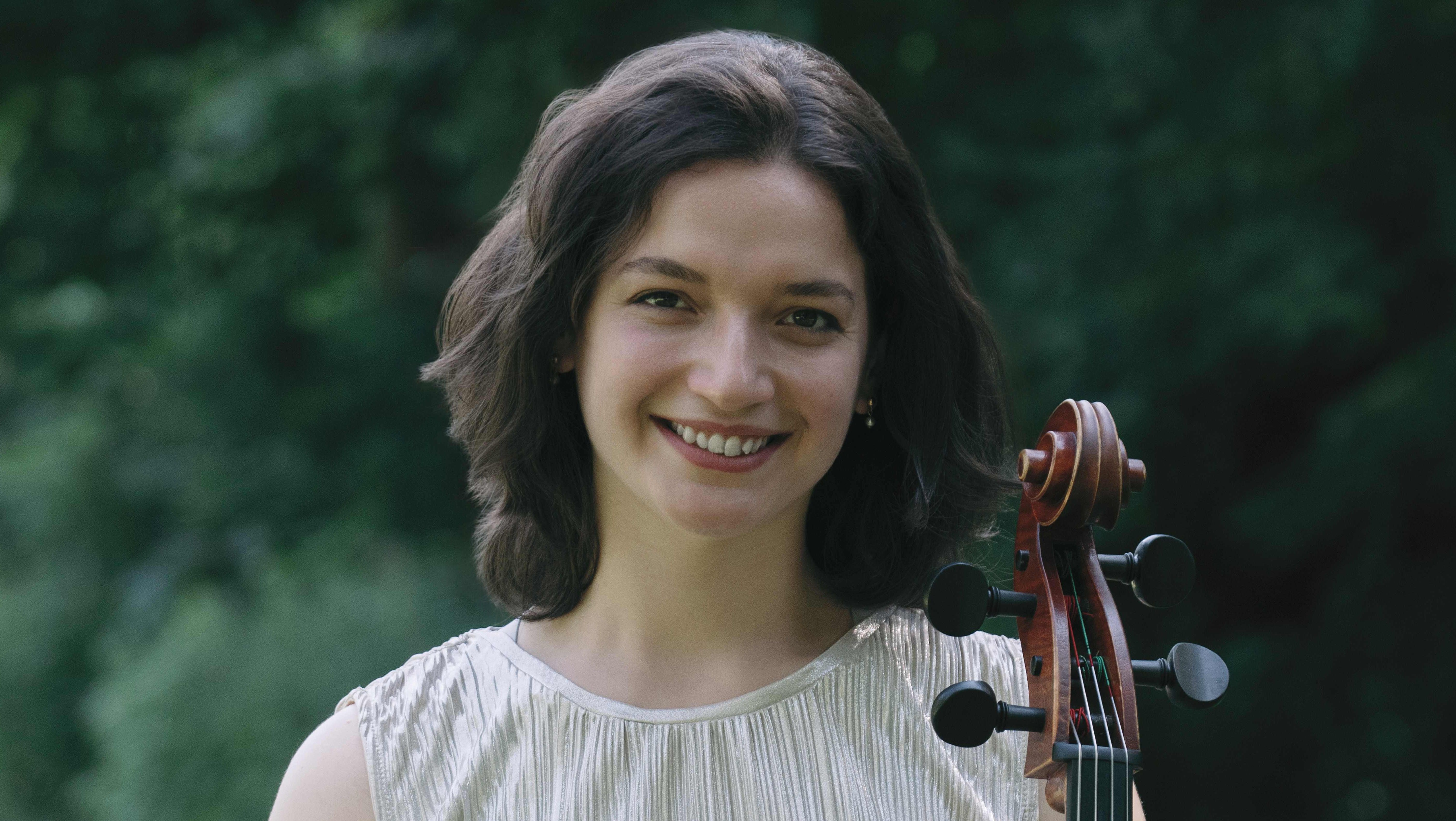 Frau mit Cello in der Hand im Park