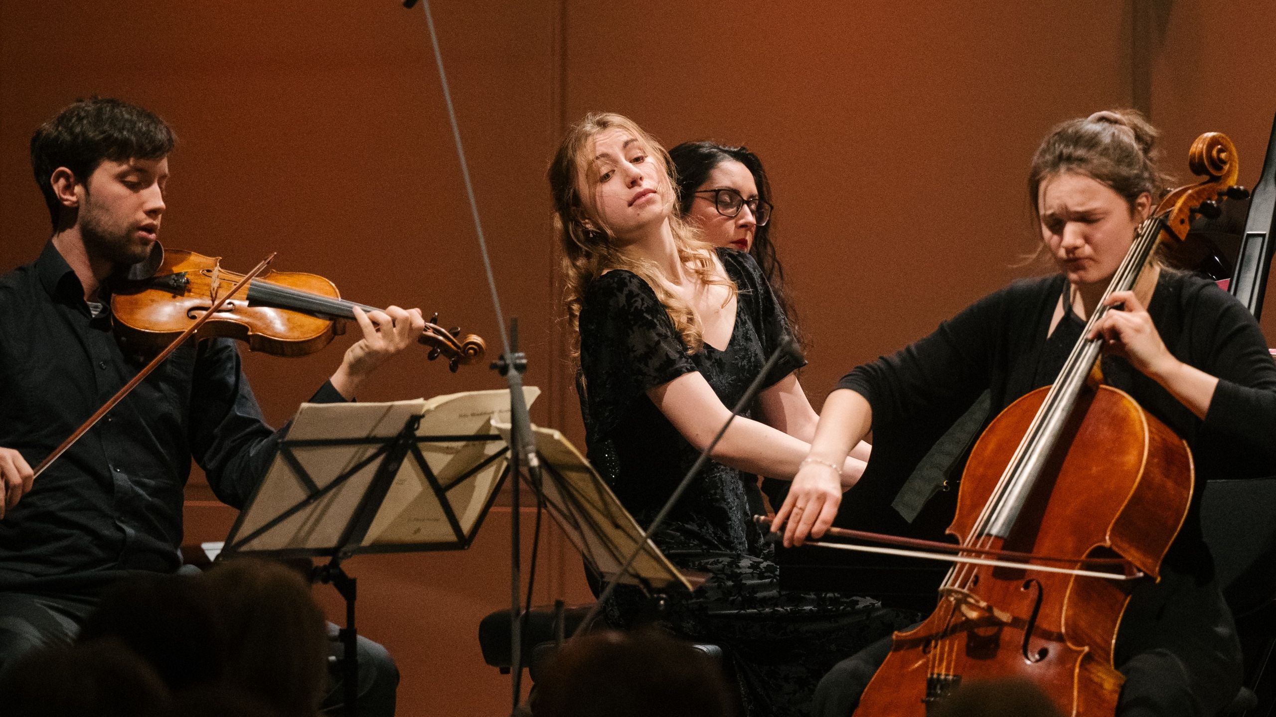 Klaviertrio mit Geiger, Cellistin und Pianist auf der Bühne