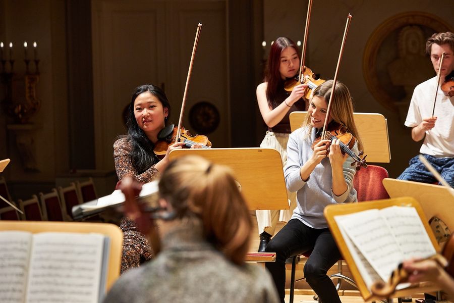 Studentinnen spielen Violine auf der Bühne im Großen Saal des Konzerthaus Berlin