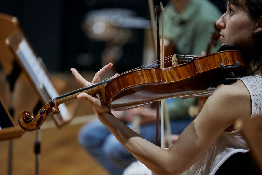 Nahaufnahme einer musizierenden Violinistin im Ensemble