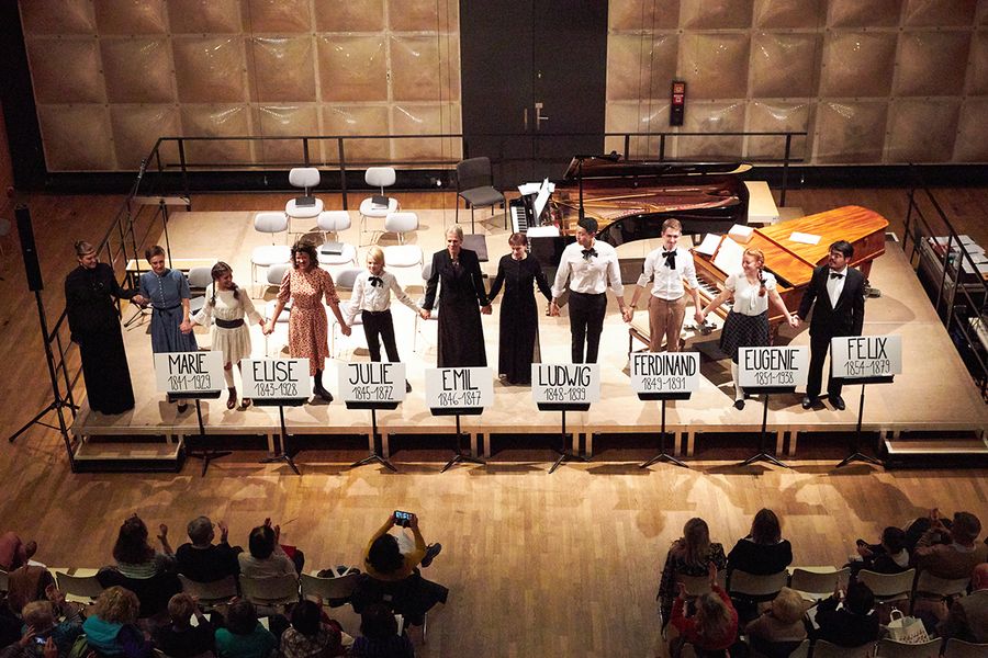 Als Kinder Familie Schumann verkleidete Studierende auf einer Bühne