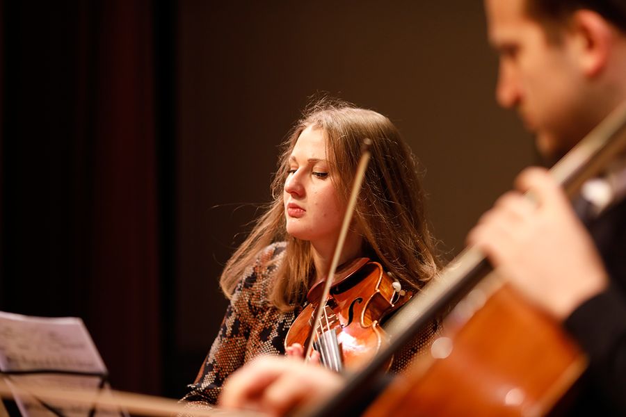Studentin spielt Geige und Student Cello