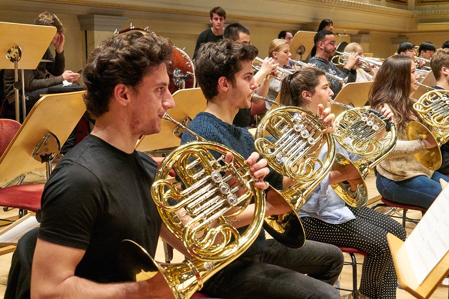 Studierende mit Hörnern und Trompeten während einer Probe