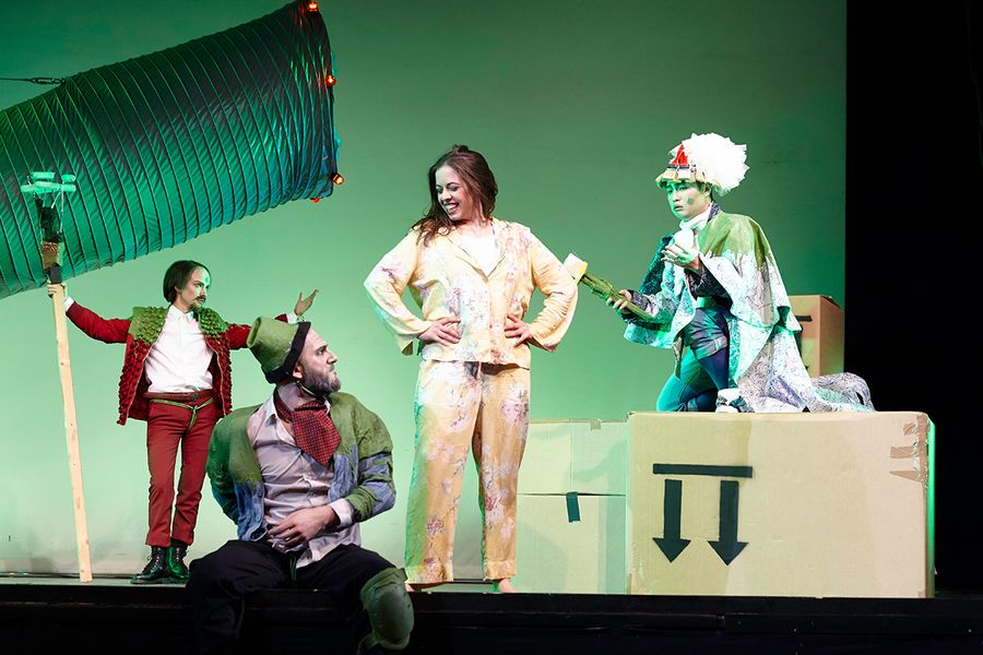 Studierende in Kostümen auf einer Opernbühne mit großen Pappkartons