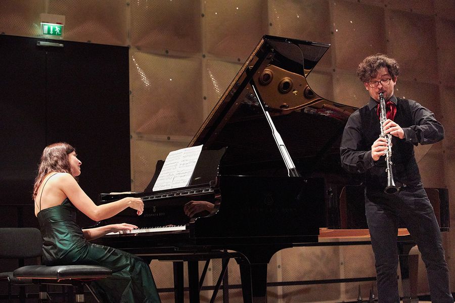 Student spielt Klarinette und Frau Klavier auf einer Bühne