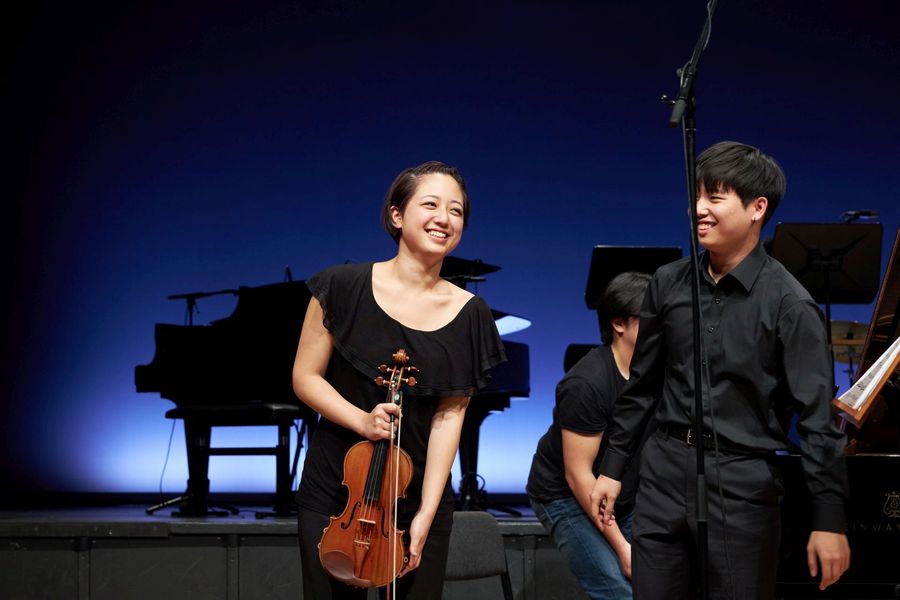 Violinistin und Pianist verbeugen sich auf der Bühne