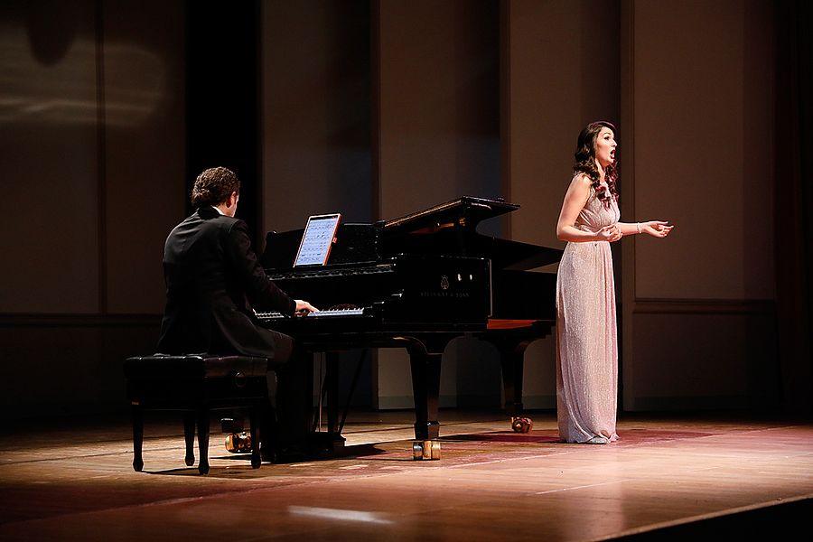 Singende Studentin und Pianist auf einer Bühne
