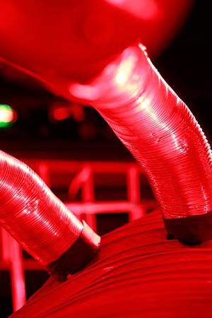 Rot angestrahltes abstraktes Gebilde aus Blechrohren