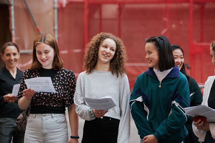 Studentinnen singen mit Noten in der Hand