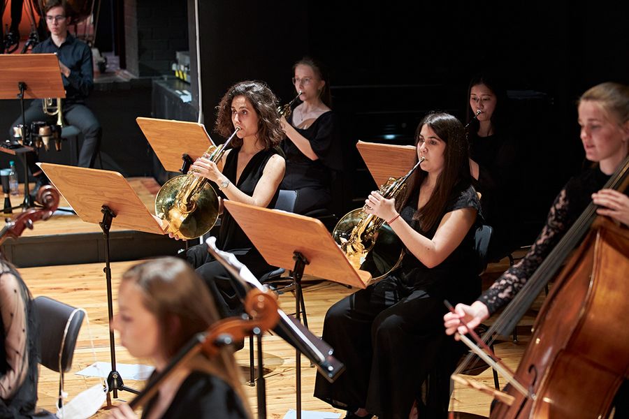 Horn spielende Studentinnen auf einer Bühne