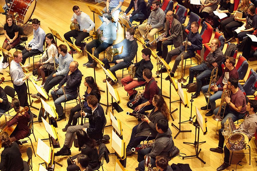 Studierende und Lehrende mit Instrumenten bei einer Orchesterprobe