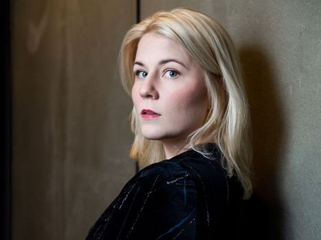 Blonde Frau vor schwarzem Hintergrund