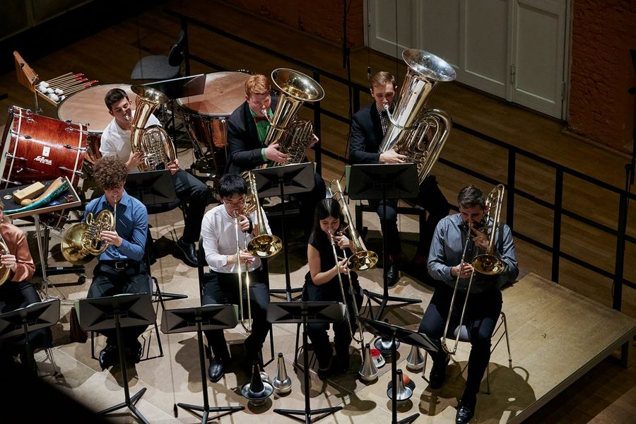 Studierende spielen Horn, Tuba und Posaune auf der Bühne des Krönungskutschen-Saals