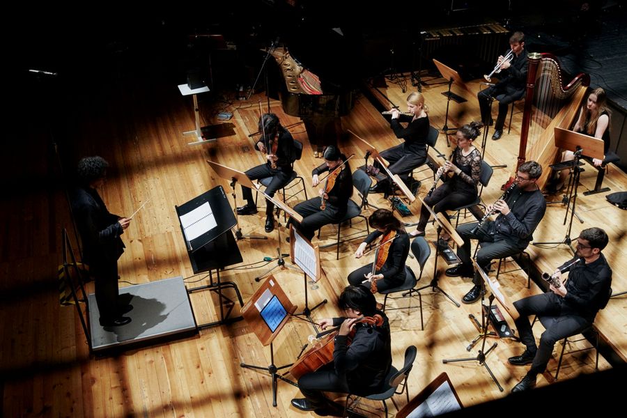 Ensemble auf der Bühne von der Seite durch ein Gitter fotografiert