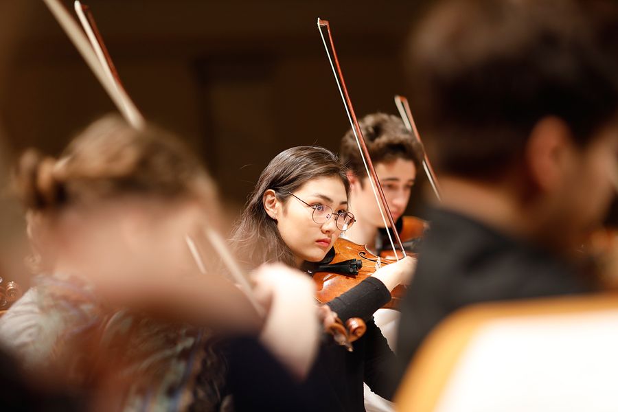 Studentin mit Geige während einer Probe