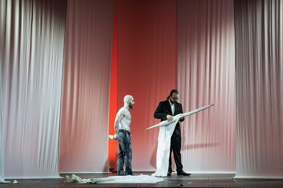Zwei Gesangstudenten auf einer Bühne mit weißen von der Decke hängenden Tuchbahnen