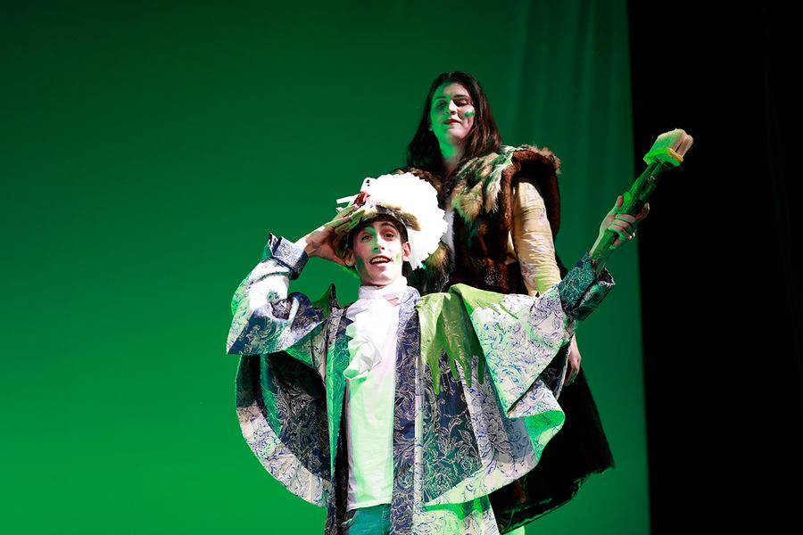 Studentin und Student in Kostümen auf einer Opernbühne
