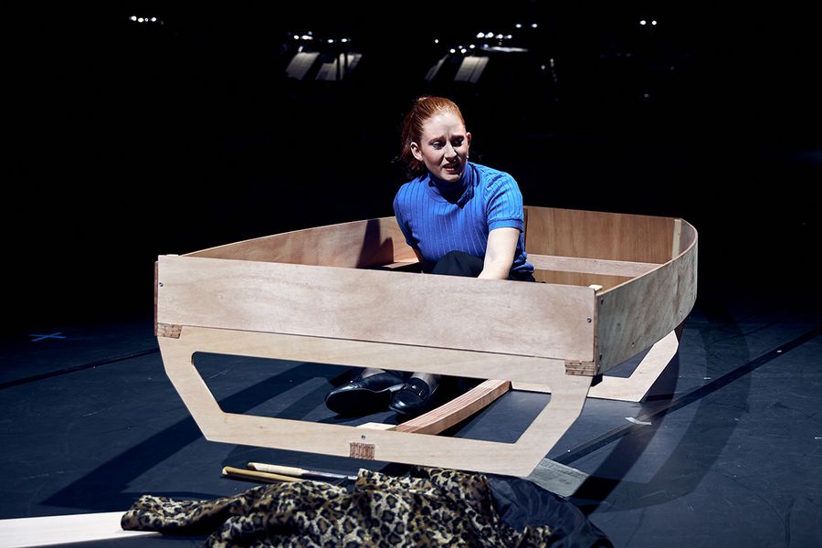 Sängerin sitzt in einem Bootgerippe aus Holz