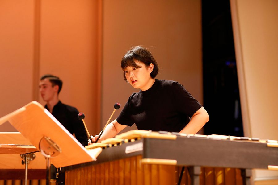 Studentin im Vordergrung spielt Marimbaphon während eines Konzerts