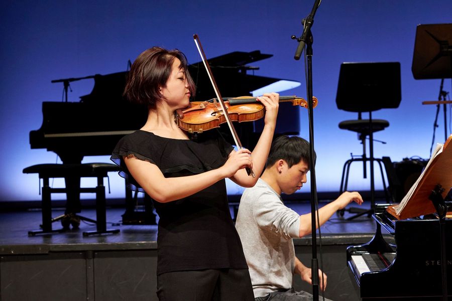 Violinistin und Pianist musizieren auf der Bühne