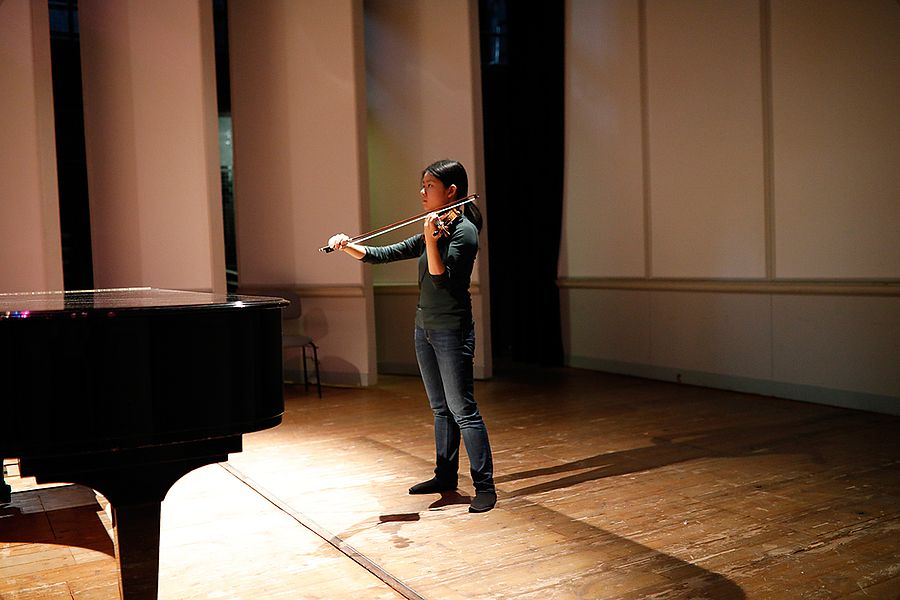 Studentin mit Geige auf einer Bühne