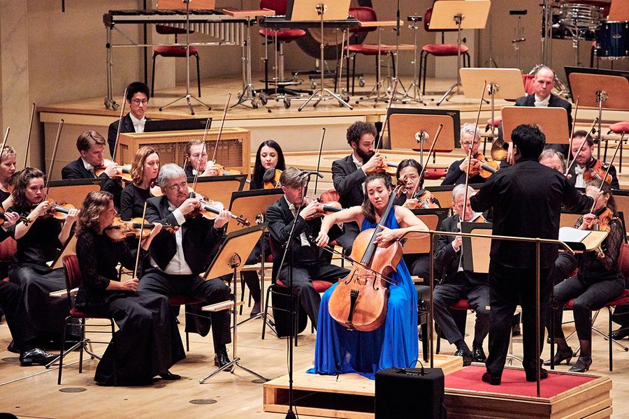 Orchester mit Cellosolistin auf einer Bühne während eines Konzertes