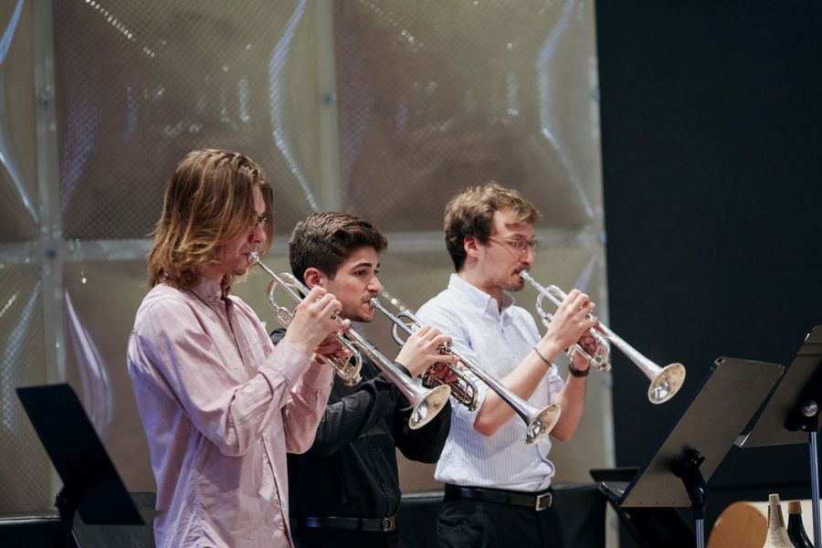 Drei Studenten spielen Trompete