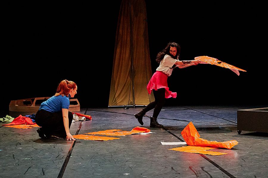 Zwei Frauen reißen orangene Buchstaben vom Boden