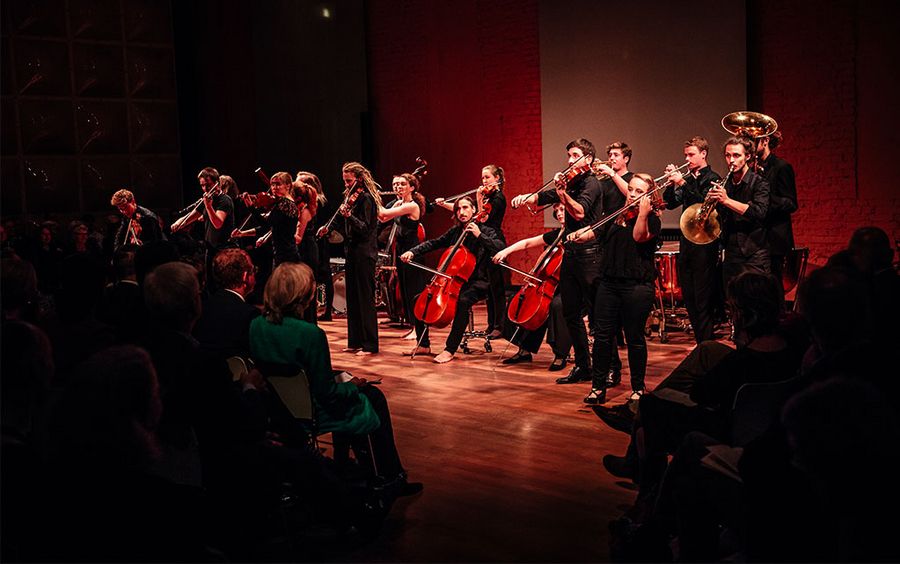 Ein Orchester steht spielend auf einer Bühne