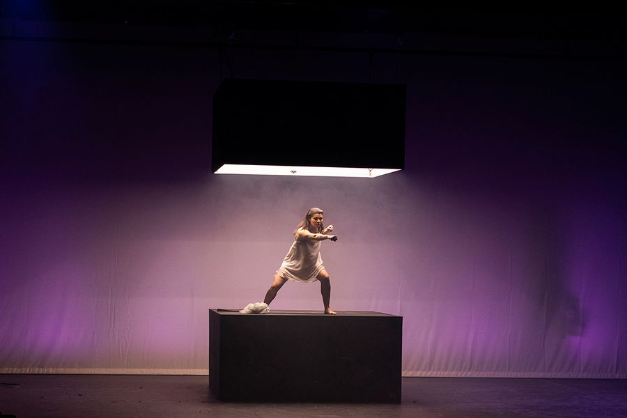 Gesangstudentin steht auf einer Kiste auf einer Bühne
