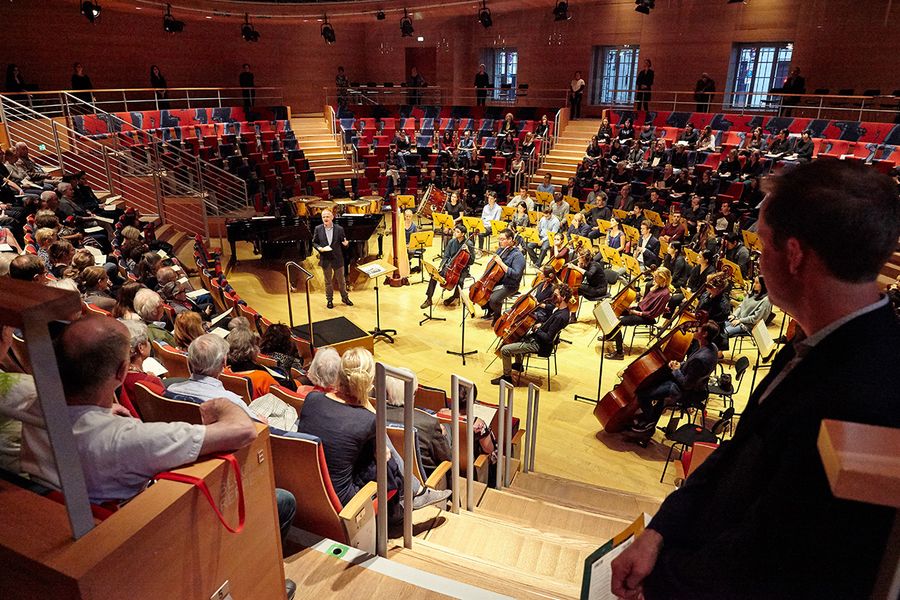 Publikum, Chor und Orchester in einem runden Konzertsaal