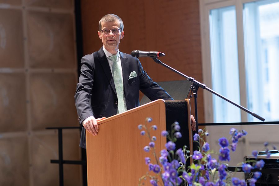 Kanzler Joachim Völz hält eine Rede stehend hinter einem Rednerpult