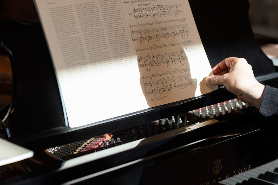 Eine Hand blättert Noten auf einem Klavierpult