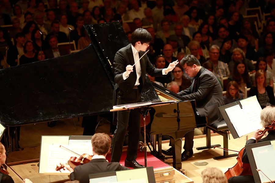 Orchester mit Dirigent und Solisten am Flügel vor Publikum im Berliner Konzerthaus