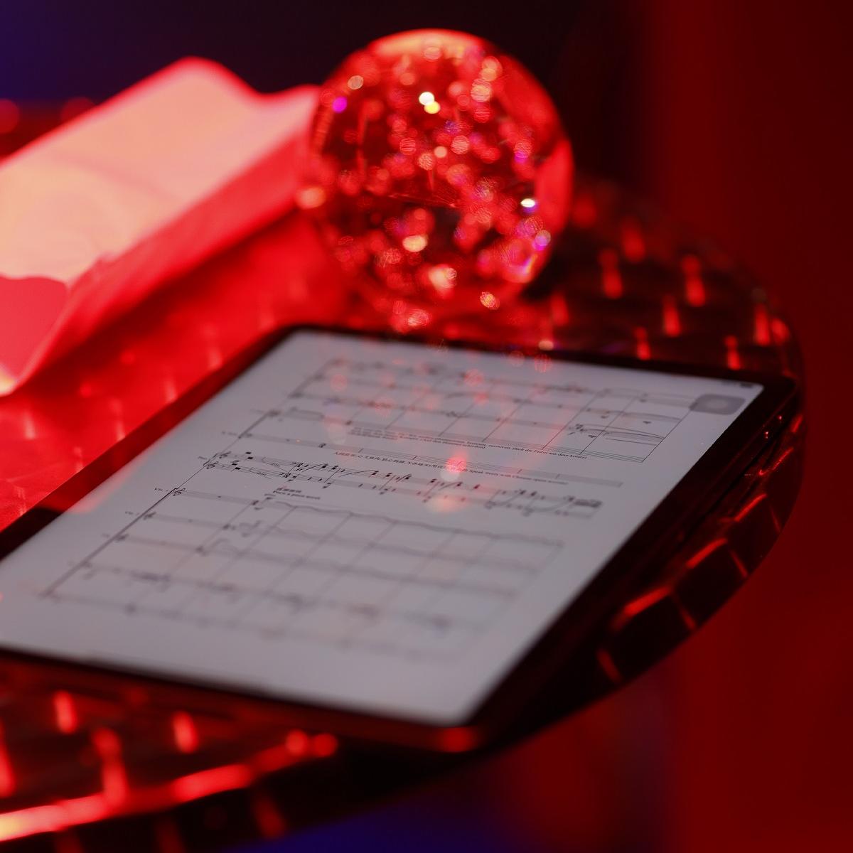 Ipad mit Noten und rot glitzernde Kugel