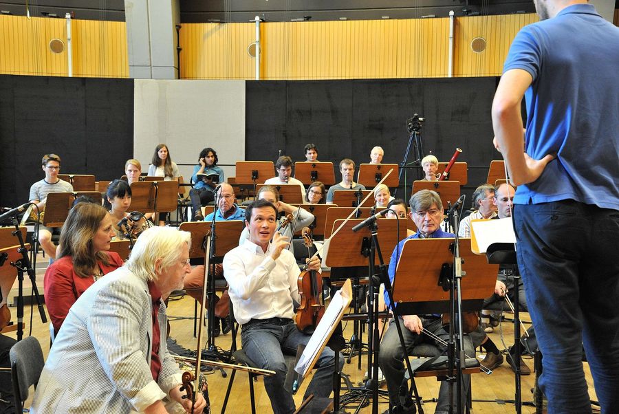 Personen mit Instrumenten während einer Orchesterprobe